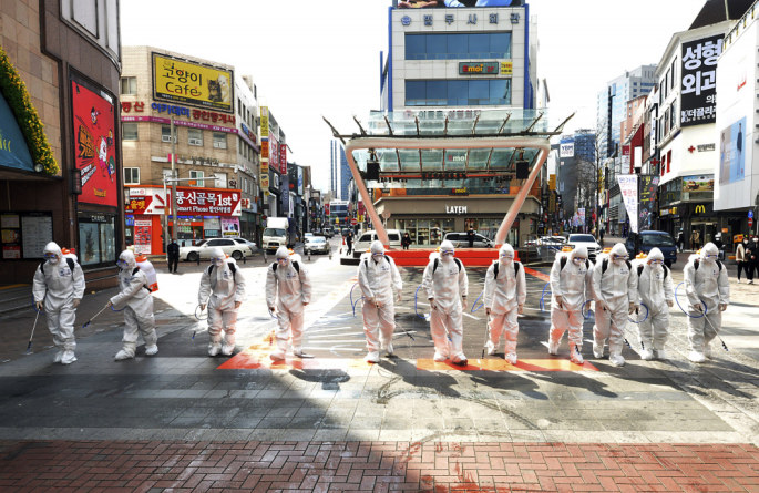 Pietų Korėjos kareiviai, dėvintys apsauginius kostiumus, purškia dezinfekavimo priemones, siekiant išvengti COVID-19 plitimo
 / „Scanpix“/AP nuotr.