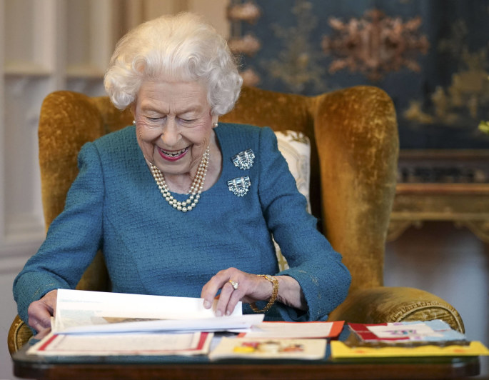 Elizabeth II apžiūri vaikų suvenyrus ir dovanėles, gautus įvairių jubiliejų proga / Scanpix nuotr.