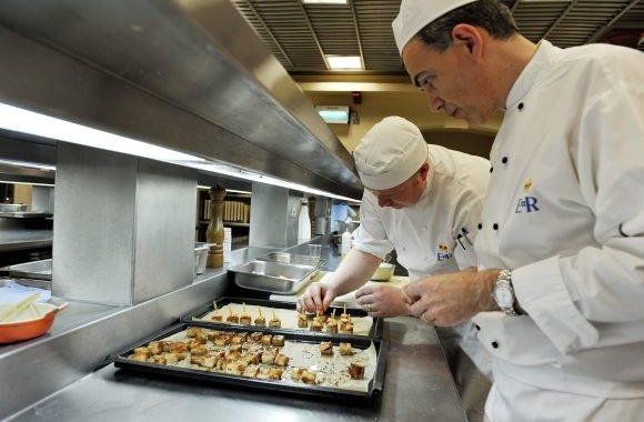 Karalienės virtuvės šefas Markas Flanaganas prižiūri, kaip Bakingemo rūmų virtuvėje gaminamas maistas.