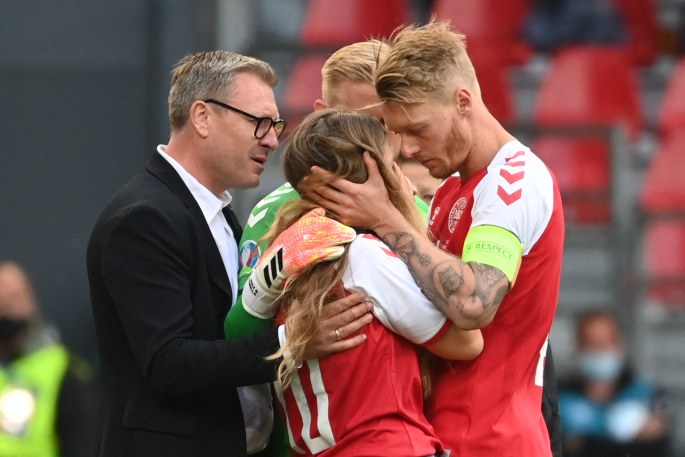 Simonas Kjaeris (dešinėje) ramina Sabriną Kvist Jensen po to, kai rungtynių metu sukniubo jos mylimasis Christianas Eriksenas / „Scanpix“ nuotr.