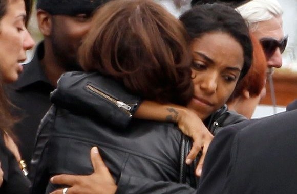 Apsikabinusios merginos Amy Winehouse laidotuvių ceremonijoje