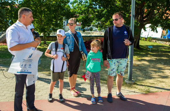 Neringos savivaldybės meras Darius Jasaitis, į kurortą atvykusiems svečiams ir vietos gyventojams dalino iniciatyvos „NE plastiko bangai“ pagamintus daugkartinio plastiko maišelius/Organizatorių nuotr.